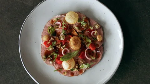 Plated presentation of dish of veal and vegetables on a fancy dish on a counter. Stock Footage 199459274