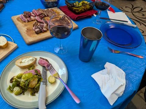 A plated steak dinner with sliced beef, buttered bread, brussels sprouts Stock Photos