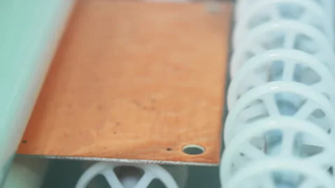 Plates are Moving Between the Rotating Plastic Rollers. Circuit board Production Stock Footage 277941754