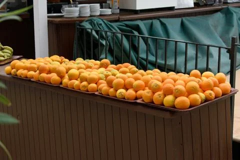 Plates full of stacked oranges on a table outdoors Stock Photos