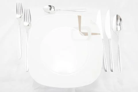 Plates with a silver fork, spoon, dessert spoon and a knife Ilustración de archivo