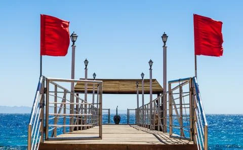 Platform on the beach with lanterns and red flags on the background of the se Foto stock