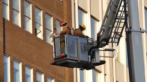 Platform with firefighters moving close of brick wall Stock Footage 90336765