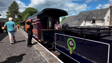Platform guard guides a historic South Tynedale Railway steam train as Stock Footage 339377904