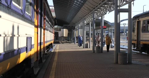 Platform in railway station, trains wait for the passengers. Winter day. Stock Footage 222963184