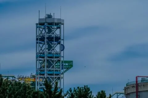 Platform tower at a gasoline storage facility on a cloudy day with pine trees Stock Photos