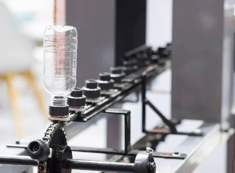 A platic bottle in shrink label machine ; Stock Photos