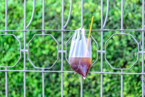 Platic garbage, plastic bag used for sparkling water was left on fence in cit Stock Photos