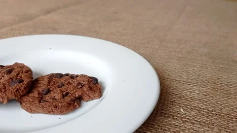 Plating the chocolate biscuits with the choco chips on a white plate Stock Footage 150398810