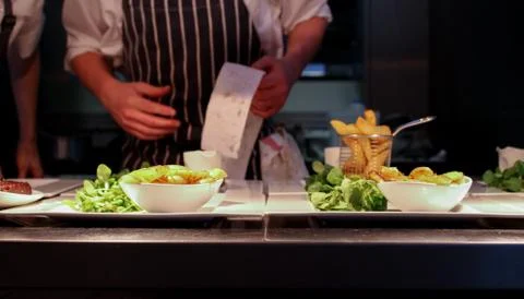Plating food in kitchen Stock Photos