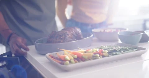 Platter and roast are resting on counter; left hand is reaching knob, adjusting Stockbeeldmateriaal 337255837
