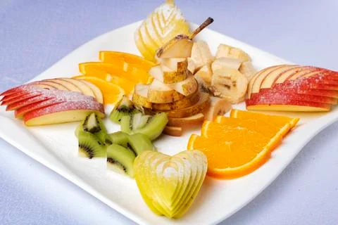 Platter of a assorted fresh fruit cut professionally on plate, close up Stock Photos