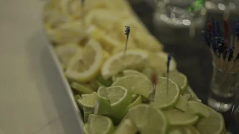 A platter of sliced lemons with a blue toothpick inserted into one slice Stock Footage 305293035