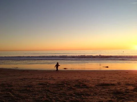 At play on beach at sunset Stock Photos