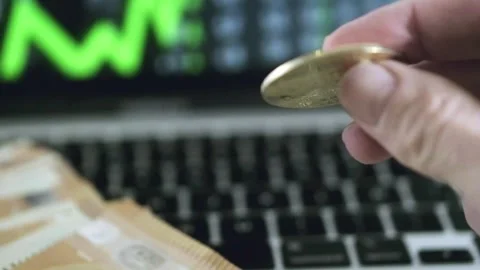 Play with bitcoin golden coin while investing trading online with laptop Stock Footage 274334791