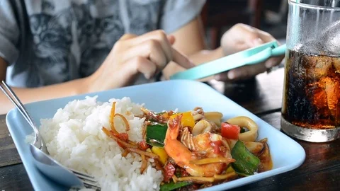 Play cellphone while Fried stir spicy sea food Stock Footage 71640120