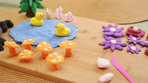 Play-doh ducks floating on pond with mushrooms and flowers Stock Footage 311436871