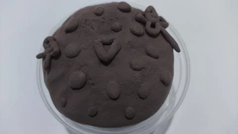 Play dough creation in a transparent container on white background Fotos Stock