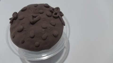 Play dough creation in a transparent container on white background Fotos Stock
