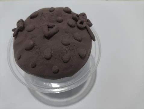 Play dough creation in a transparent container on white background Fotos Stock