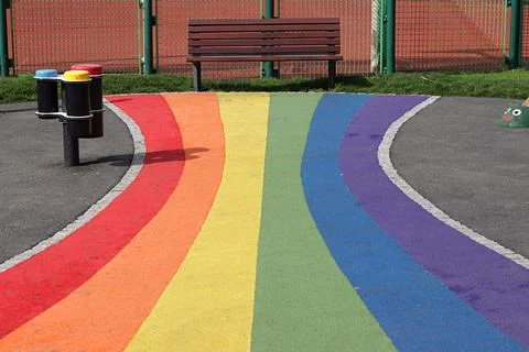 Play ground,rainbow path to a bench in a public garden. Stock Photos