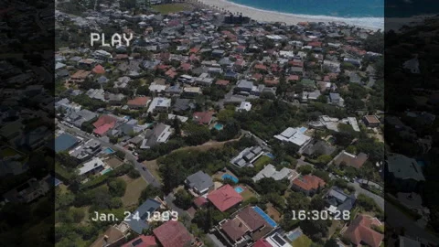 PLAY indicator appearing starting drone panning over rooftops toward beach Video stock 313757942