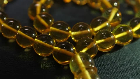 The Play of Light on Amber Beads. Reflection and Iridescence. Stock Footage 151386664
