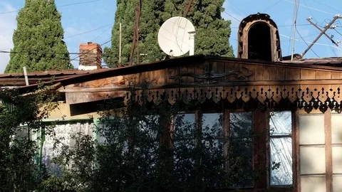 The play of light and shadow on an old wooden house with a satellite dish Stock Footage 84075545
