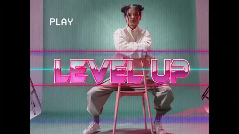 PLAY overlay appearing, model sitting backward on pink stool, adjusting jacket, Stock Footage 332822025