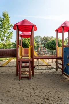 Play structure with red roofs and climbing features in a sunny playground Stock Photos