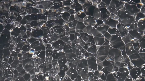 Play of sun light on waving gray water surface close up. Stock Footage 96887846
