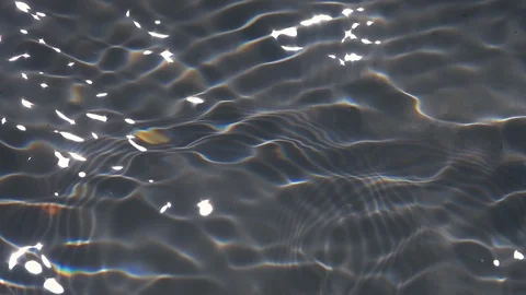 Play of sun light in waving shallow water with gray textured bottom close up. Stock Footage 96887889