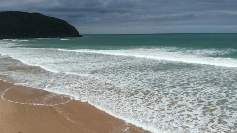 Playa con olas y cielo encapotado con nuves oscuras Stockbeeldmateriaal 145975959