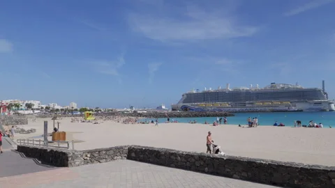Playa de los Pozos or Playa Chica beach with cruise ship moored in the harbour Stock Footage 303699618