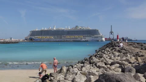Playa de los Pozos or Playa Chica beach with cruise ship moored in the harbour Stock Footage 303699682