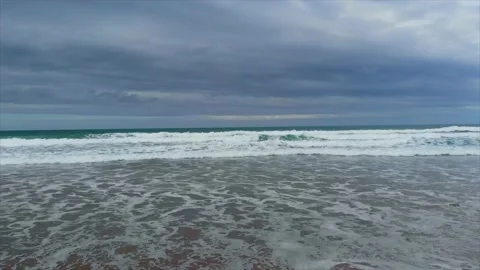 Playa y olas con cielo oscuro Stockbeeldmateriaal 145975957