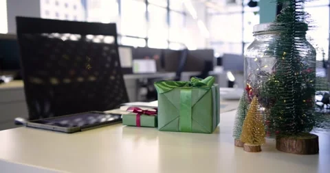 Playback starting camera panning right on office desk revealing gift boxes Stock Footage 336957350