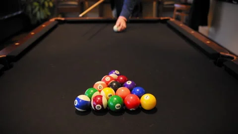 Player breaking racked pool balls in eight ball formation on pool table for Видео 313455021
