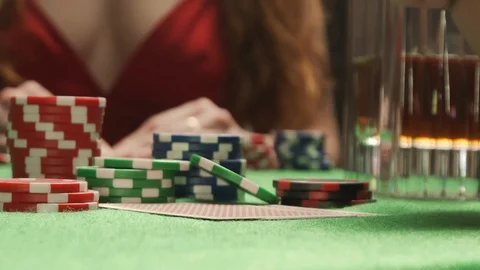 Player checking his poker hand. Pair of aces. On the background is woman in red Stock Footage 125982925