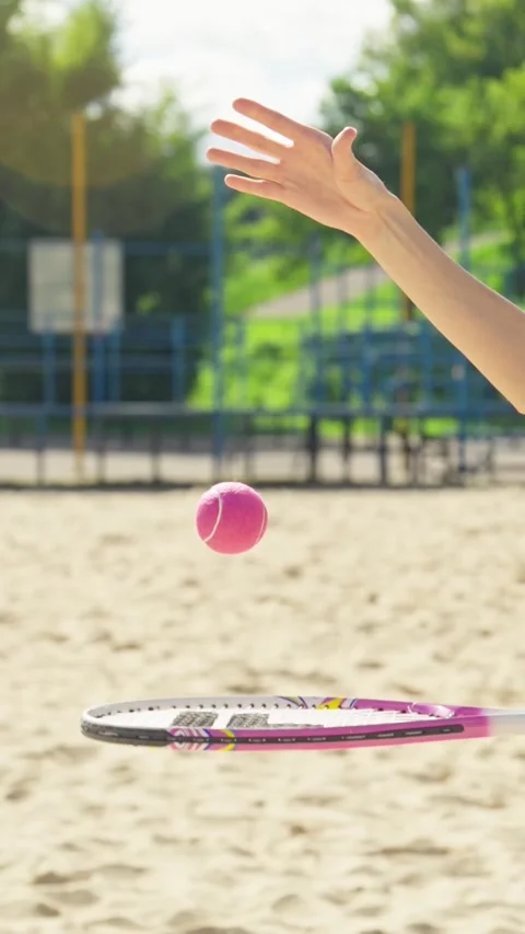 Player elegantly tosses bright pink ball into air while getting ready to serve Видео 334102796