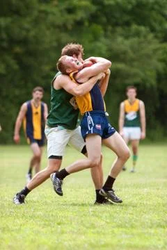 Player grimaces while being tackled in australian rules football game Stock Photos