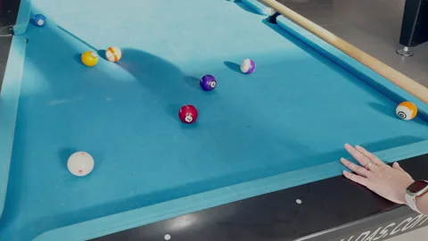 Player Hitting Billiard Ball on Blue Pool Table During Game Stock Footage 339429811