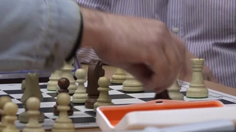 A player makes a move with the queen and presses the clock. Stock-Footage 332807575
