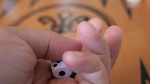 A player is preparing a dice for the roll while playing a backgammon game Vidéo 291886603