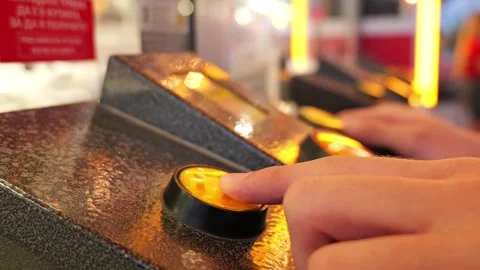 Player pressing a yellow button on arcade game console Stock Footage 340280946