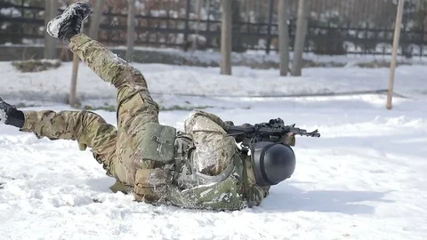 The player is in the snow, and fired from automatic weapons. Play airsoft in the Stock Footage 72984692