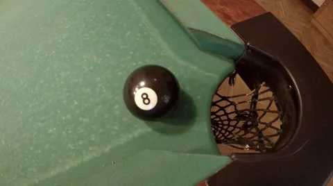 Player successfully hits 8 ball in corner pocket on a green pool table Stock Footage 46893201