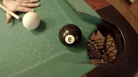 Player successfully hits 8 ball in corner pocket on a green pool table Stock Footage 46893231