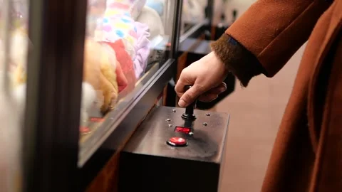 Player uses claw machine to win stuffed toys at arcade Stock Footage 337243060