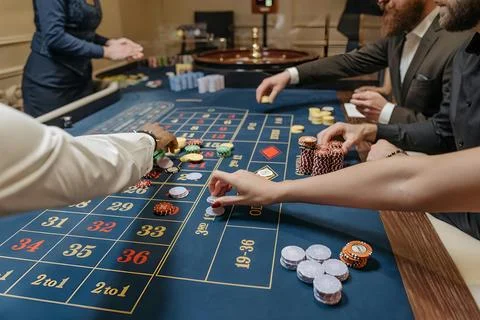 Players betting on roulette table inside casino Stock Photos